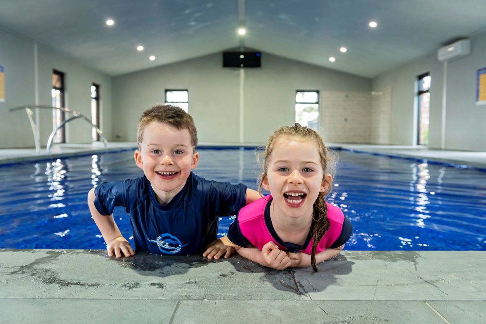 Two children holding onto the edge of Geelong indoor pool